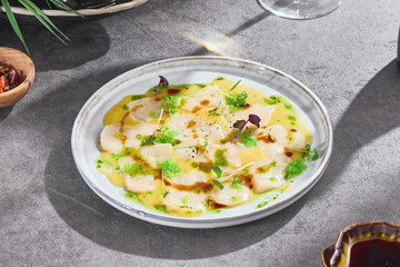 Scallop carpaccio, bright natural lighting, overhead composition with citrus sauce and herb garnish