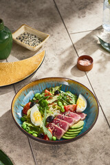 nicoise salad with medium-seared tuna in bright natural lighting, overhead composition