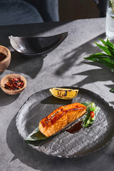 Miso-glazed salmon steak, bright rustic lighting, overhead composition on artisanal black plate