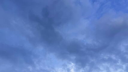 Fototapeta premium Dramatic Sky Overcast with Blue Gaps and Dark Cloud Formations Underneath a Cloudy Layer