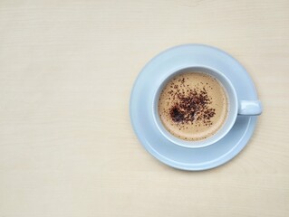 Cappucino coffe in glass on wooden table background. Flat lay, copy space 