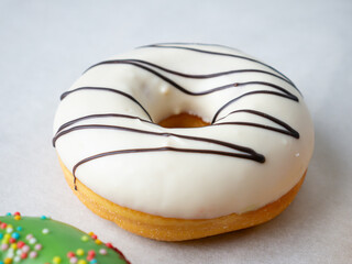 Donuts with different colorful icing designs on a white background.
