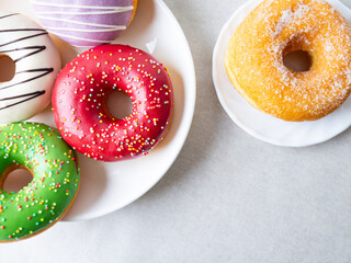 Donuts with colorful icing glazed designs on a white background. Copy free space