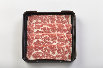 Freshly sliced marbled beef arranged neatly in black tray, showcasing its rich texture and vibrant red color, perfect for grilling or hot pot dishes