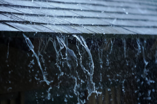 Heavy rainwater flows from the roof - Powered by Adobe