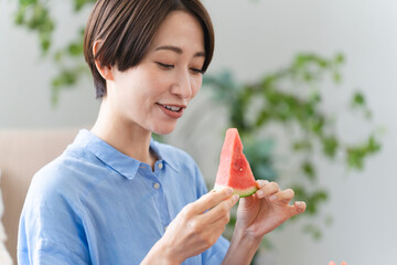 西瓜を食べる若い女性　ライフスタイルイメージ
