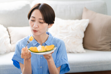メロンを食べる若い女性　ライフスタイルイメージ