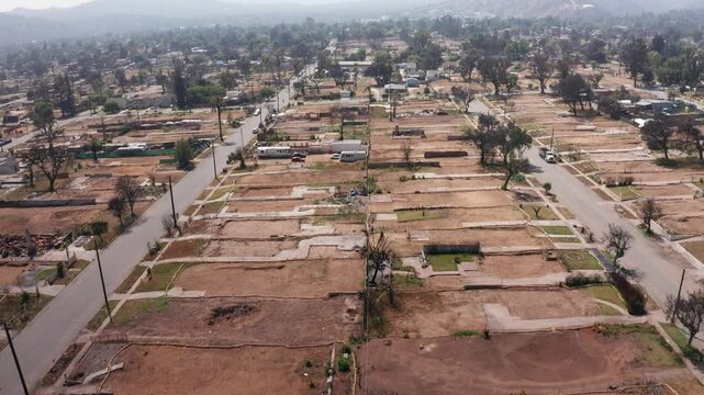 Aerial tilting-up shot flying over cleared residential lots in the aftermath of the Eaton Fire in Altadena, California. 4K