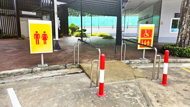 Public Restroom Signage: Signage indicates public restroom access, emphasizing inclusivity and accessibility for all, including those with disabilities, at a building entrance.