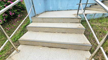Stone Steps with Railing: A perspective view of a short flight of stone steps leading upwards,...