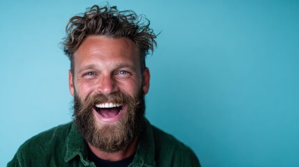 A joyful and bearded man bursts into laughter beneath a bright blue background, radiating warmth and positivity with his dynamic energy and genuine expression.