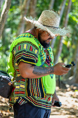 Local videographer recording in a lush Costa Rican forest, showcasing the beauty of the Caribbean nature while wearing traditional clothing