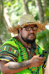 Local videographer recording in a lush Costa Rican forest, showcasing the beauty of the Caribbean nature while wearing traditional clothing