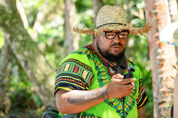 Costa Rican local man in Caribbean shirt consulting a video camera in Cahuita National Park, Costa...