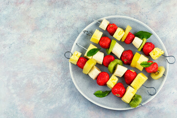 Plate of mixed fruits on skewers.