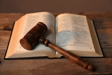 Judge's gavel and Bible on wooden table, closeup