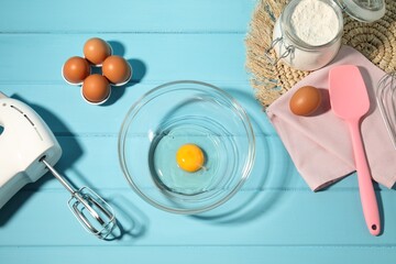 Making whipped cream. Bowl, hand mixer and ingredients on light blue wooden table, flat lay
