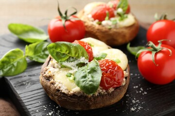 Tasty stuffed mushrooms served on wooden table, closeup