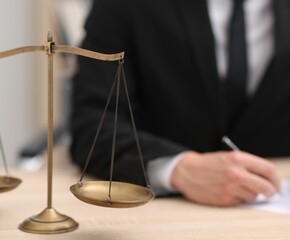 Judge working and scales on desk indoors, selective focus