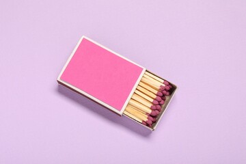 Matches in box on violet background, top view. Mockup for design