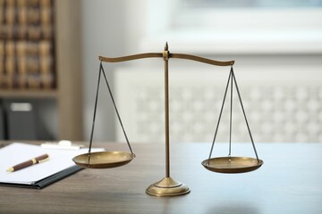 Judge's workplace with scales and clipboard on wooden table in office, closeup