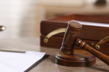 Judge. Gavel and clipboard on wooden table in office, closeup