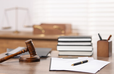 Judge. Gavel, books, papers and pen on wooden table in office, selective focus