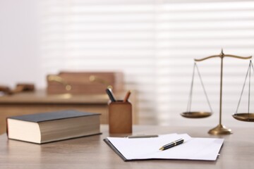 Judge. Scales, book, papers and pen on wooden table in office