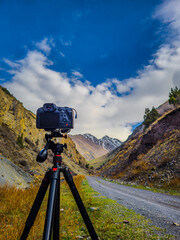 Camera mounted on tripod in serene mountainous valley