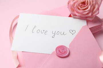 Stack of letters, card with phrase I Love You and rose flower on pink background, closeup