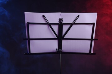 Stand with music sheets on dark background with smoke