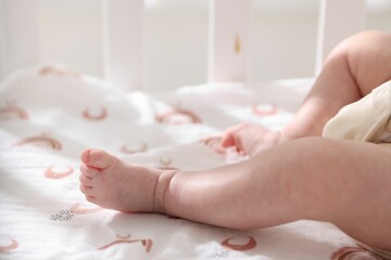 Cute newborn baby lying in crib, closeup
