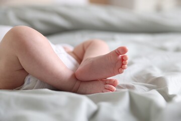 Cute newborn baby lying on bed, closeup