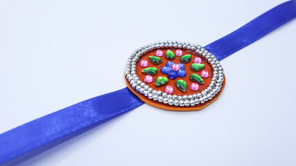 Beautiful hand crafted Rakhi made of beads, kundan and ribbon on felt sheet. Handmde rakhi on white backgrounf