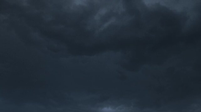 Dramatic storm clouds gather over a tranquil landscape at dusk
