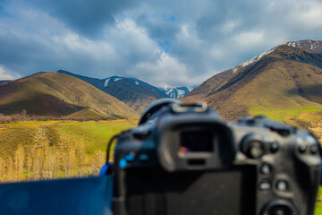 Camera capturing majestic Kyrgyzstan mountain range in serene outdoor setting