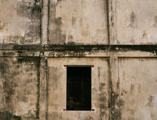 Old grungy concrete wall with empty window frame