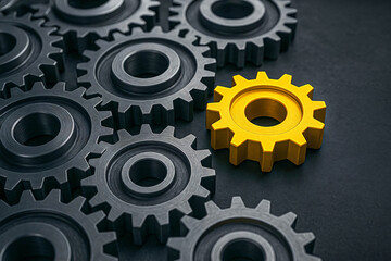 One Yellow Gear Standing Out Among Grey Interconnected Gears