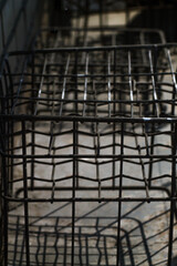 An intricate close-up reveals the precise geometric patterns of a dark metal grid, casting sharp...