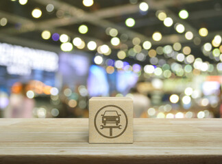 Service fix car with wrench tool flat icon on wood block cube on wooden table over blur light and shadow of shopping mall, Business repair car service concept