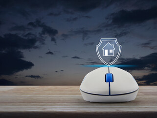 Home with shield flat icon on wireless computer mouse on wooden table over sunset sky, Business home insurance and security online concept
