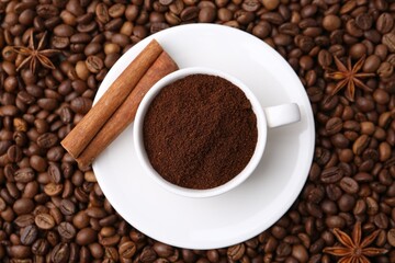 Cup with instant coffee powder and cinnamon on beans, top view