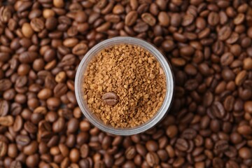 Glass jar with granulated instant coffee on beans, top view