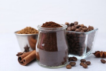 Different types of instant coffee, beans and spices on light table, closeup