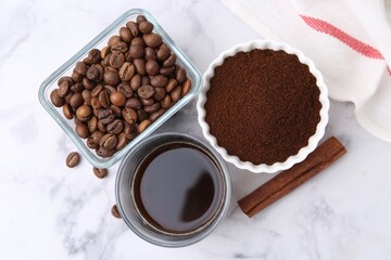 Instant coffee powder, beans and drink on white marble table, flat lay