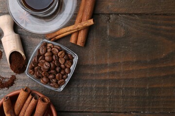 Roasted beans, instant coffee powder and cinnamon sticks on wooden table, flat lay. Space for text
