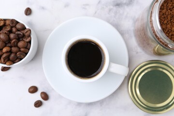 Aromatic hot drink, instant coffee and beans on white marble table, flat lay