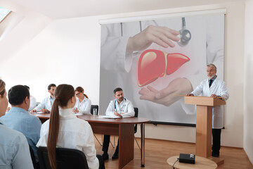 Healthcare professional giving lecture about liver in conference room using video projector....