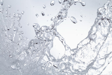 グレーの背景に飛び散る水飛沫.