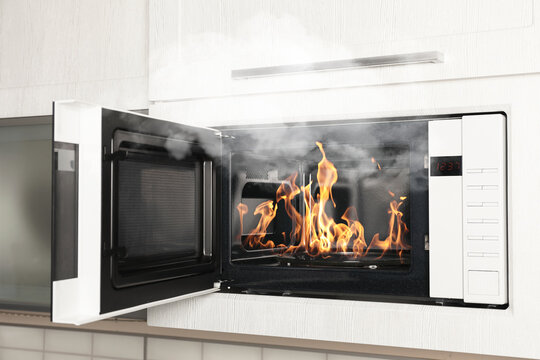 Fire and smoke in microwave oven in kitchen